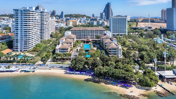 Un hotel costero con varias construcciones, una playa y una zona de piscina.