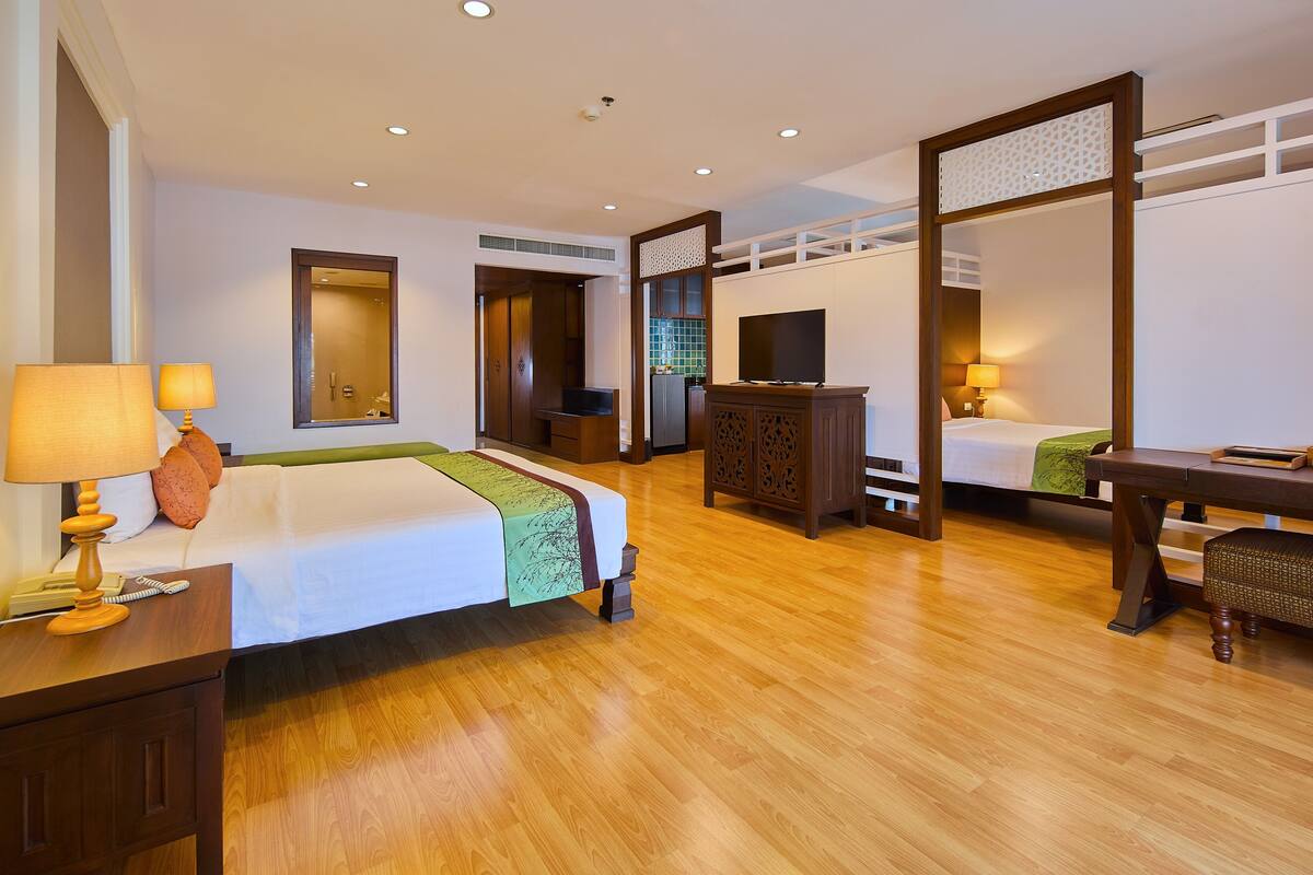 Une chambre d’hôtel avec un lit, un bureau, une télévision et un miroir.