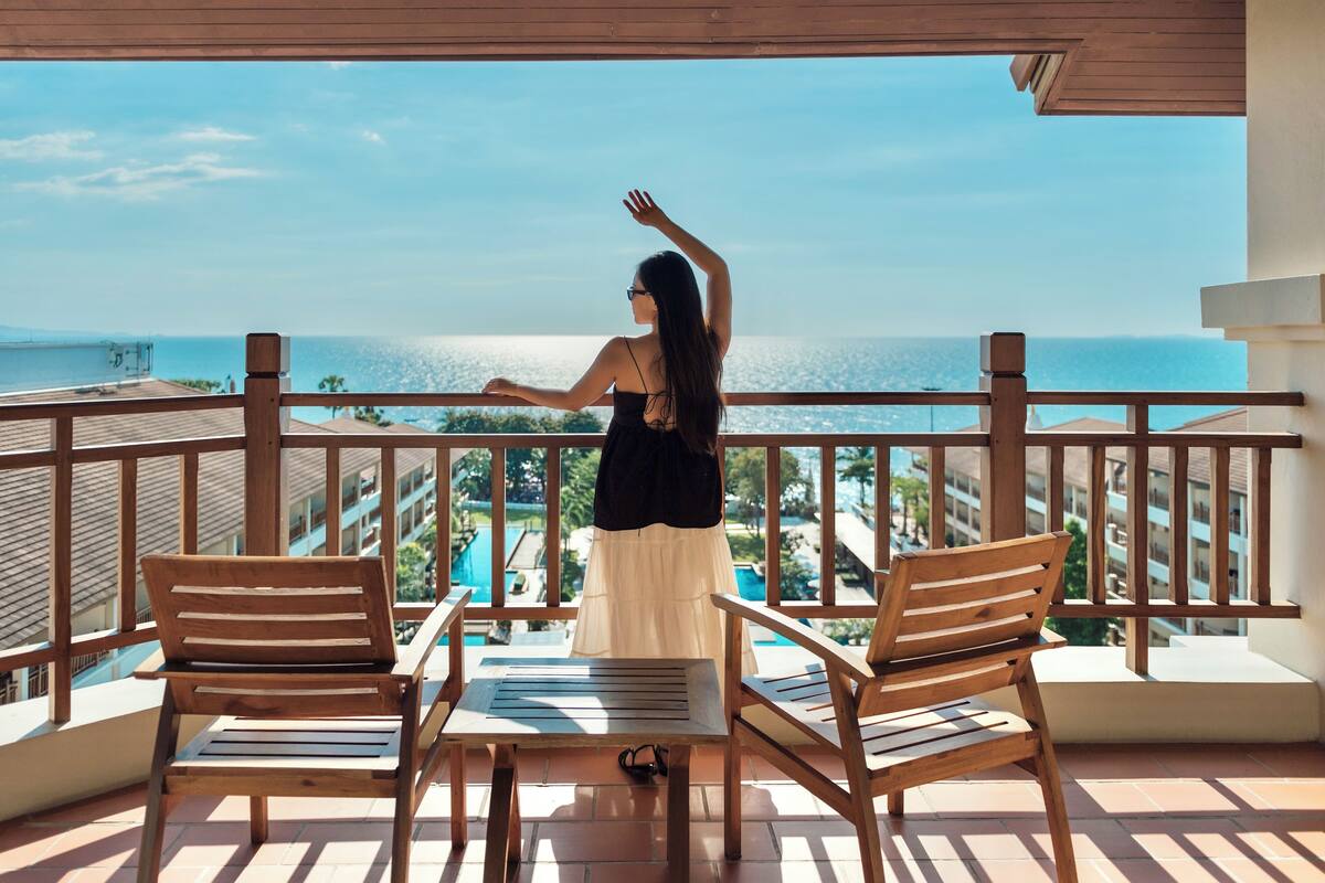 Un balcon doté de mobilier en bois et offrant une vue sur la mer.