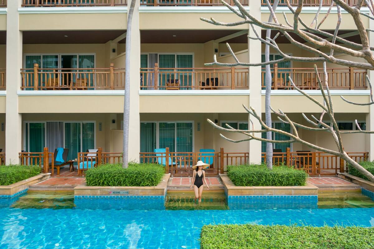 Un hôtel doté d’une piscine, de plusieurs balcons et d’espaces extérieurs aménagés pour se détendre.