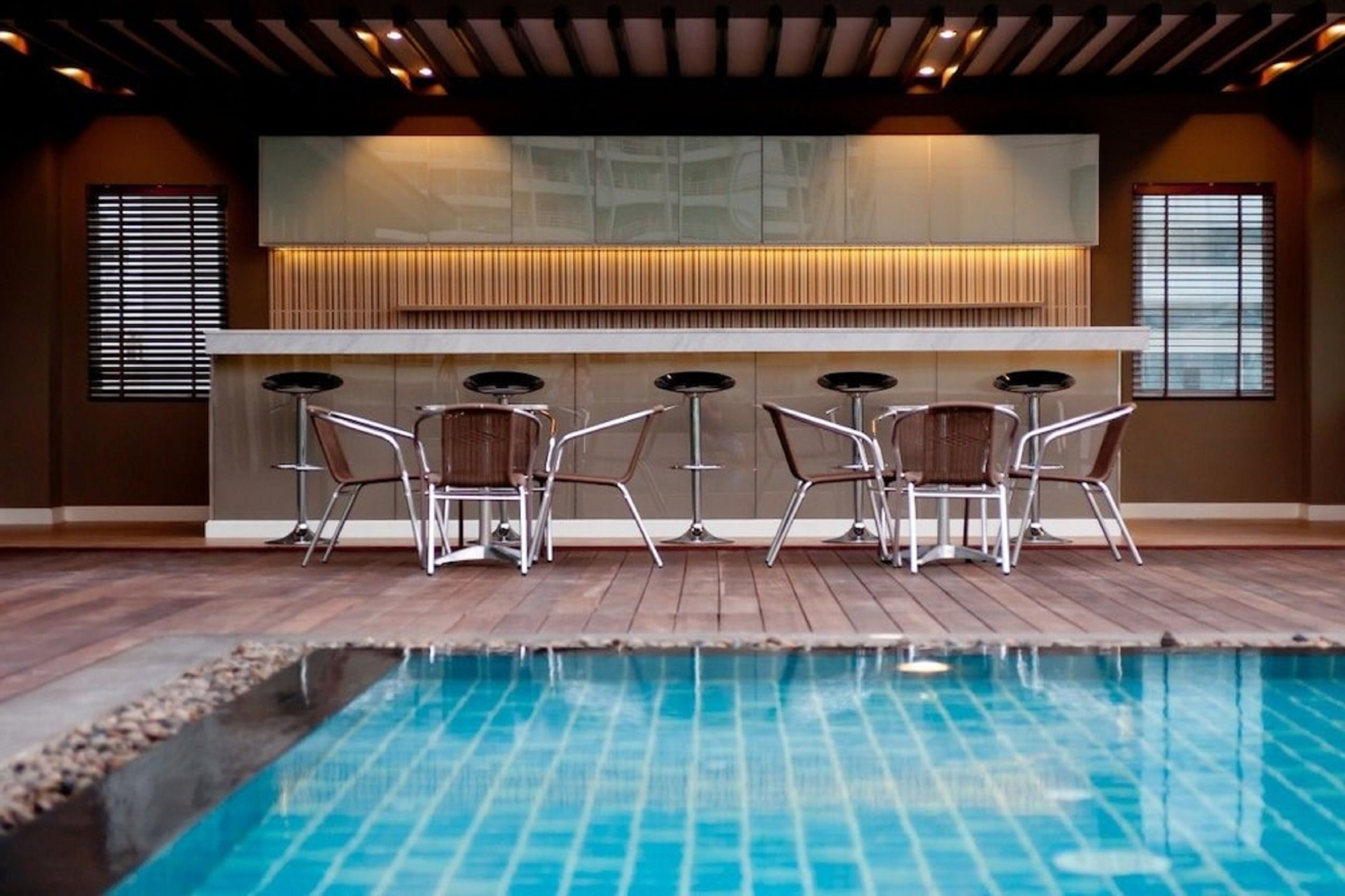 Una piscina al aire libre, sillones reclinables de piscina