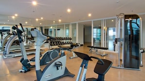 A gym with cardio machines, dumbbells, and a weightlifting area. - The Stay Hotel (Pattaya)