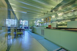 A modern kitchen with a dining area, large windows, and a view of the city. - GranDELUX-Canal (Venice)