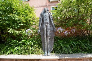 A statue of a figure in a garden setting. - GranDELUX-Canal (Venice)
