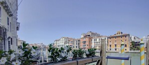 A private Grand Canal deck with a wooden railing, a bench, and white flowers. - GranDELUX-Canal (Venice)