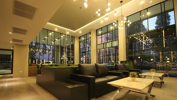 A modern lobby with a sofa, tables, and large windows. - Season Five Hotel (Pattaya)