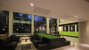 A modern lounge area with a pool table, comfortable seating, and large windows offering views of the cityscape. - Season Five Hotel (Pattaya)