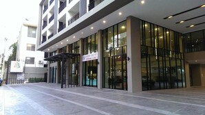 A modern building with large glass windows and a covered entrance. - Season Five Hotel (Pattaya)