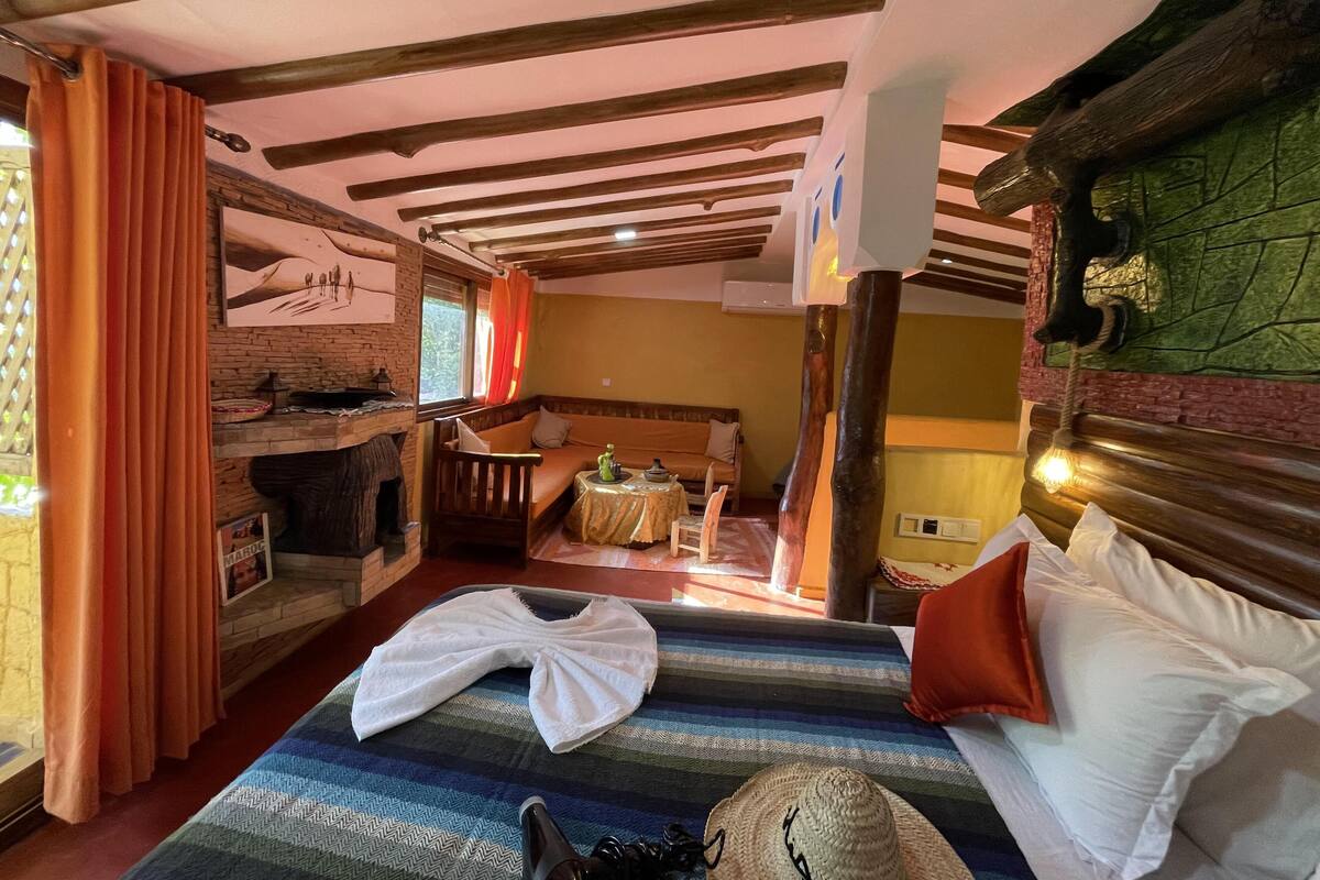 Um quarto acolhedor com uma cama, uma mesinha, um sofá e uma lareira.