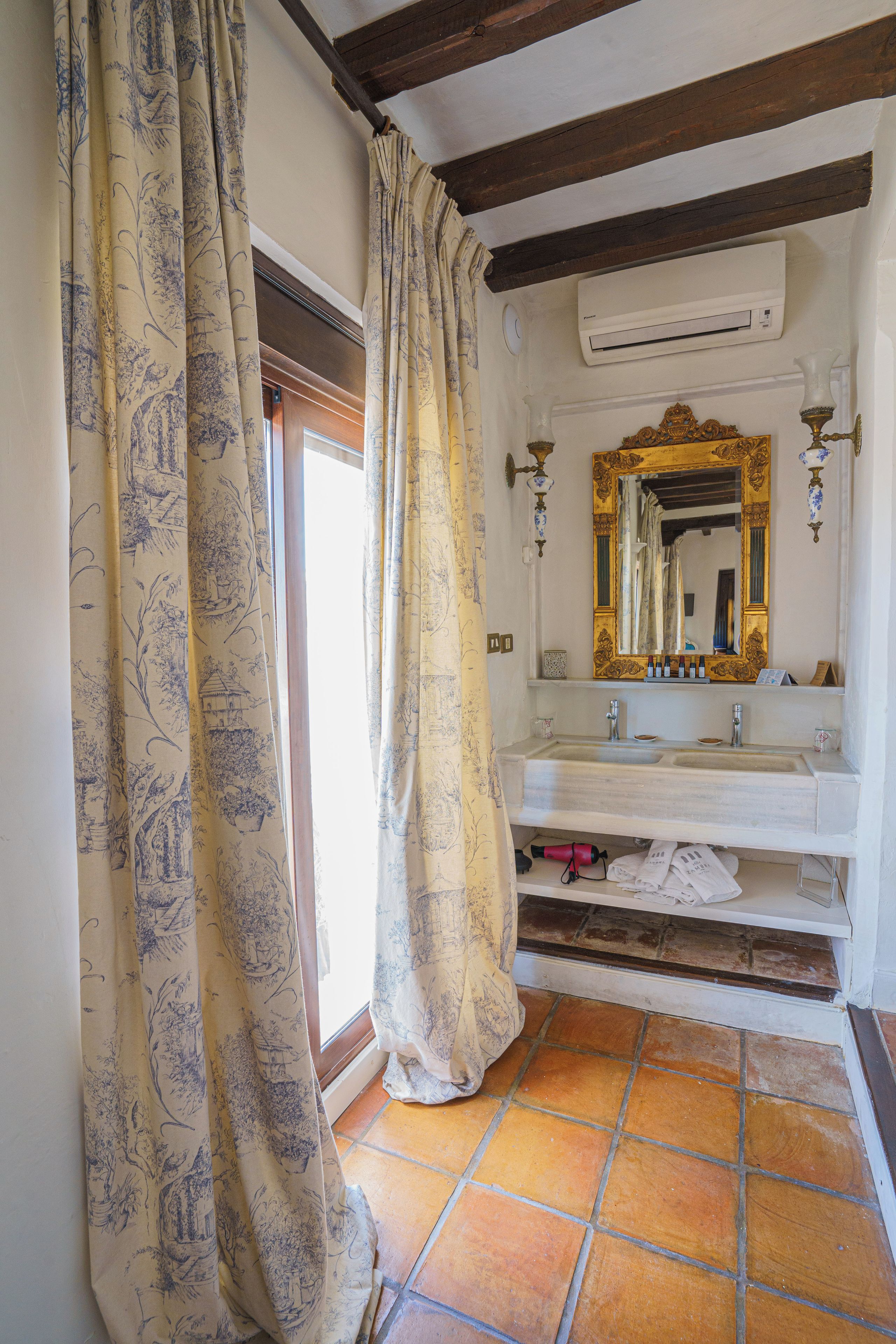 A bathroom with a large mirror, a sink, and a shower area.