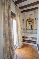 Un baño con un espejo grande, un lavabo y una zona de ducha.