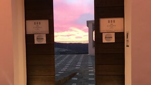 Una entrada arqueada a un edificio con vista al atardecer. Se ven letreros que indican 'villa Zambra' y acceso 'Privado'.