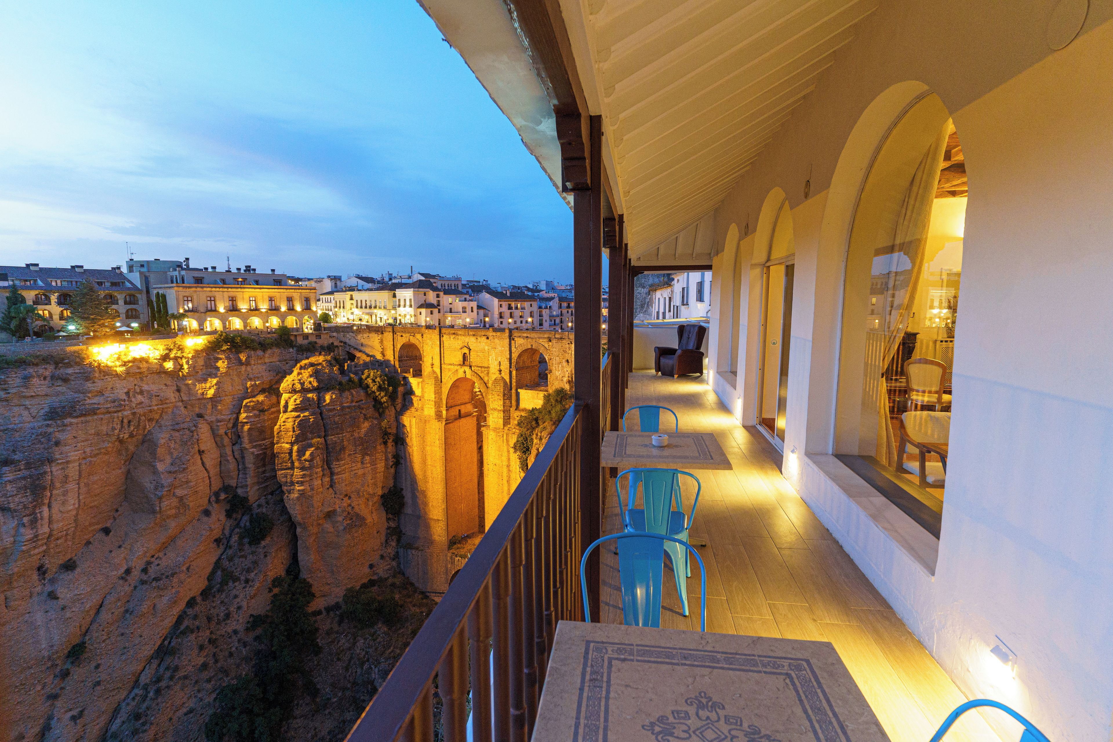 A balcony with a view of a historic stone bridge and buildings.