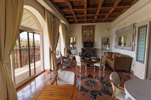 Un salón amplio con chimenea, asientos cómodos y vistas al balcón.