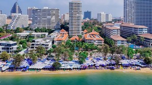 A coastal cityscape with high-rise buildings, a beach with umbrellas, and a prominent hotel with a red-roofed structure. - Avalon Beach Resort Pattaya (Pattaya)
