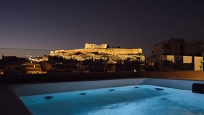 A rooftop pool with a view of a historic building at night. - Urban Stripes Athens (Athens)