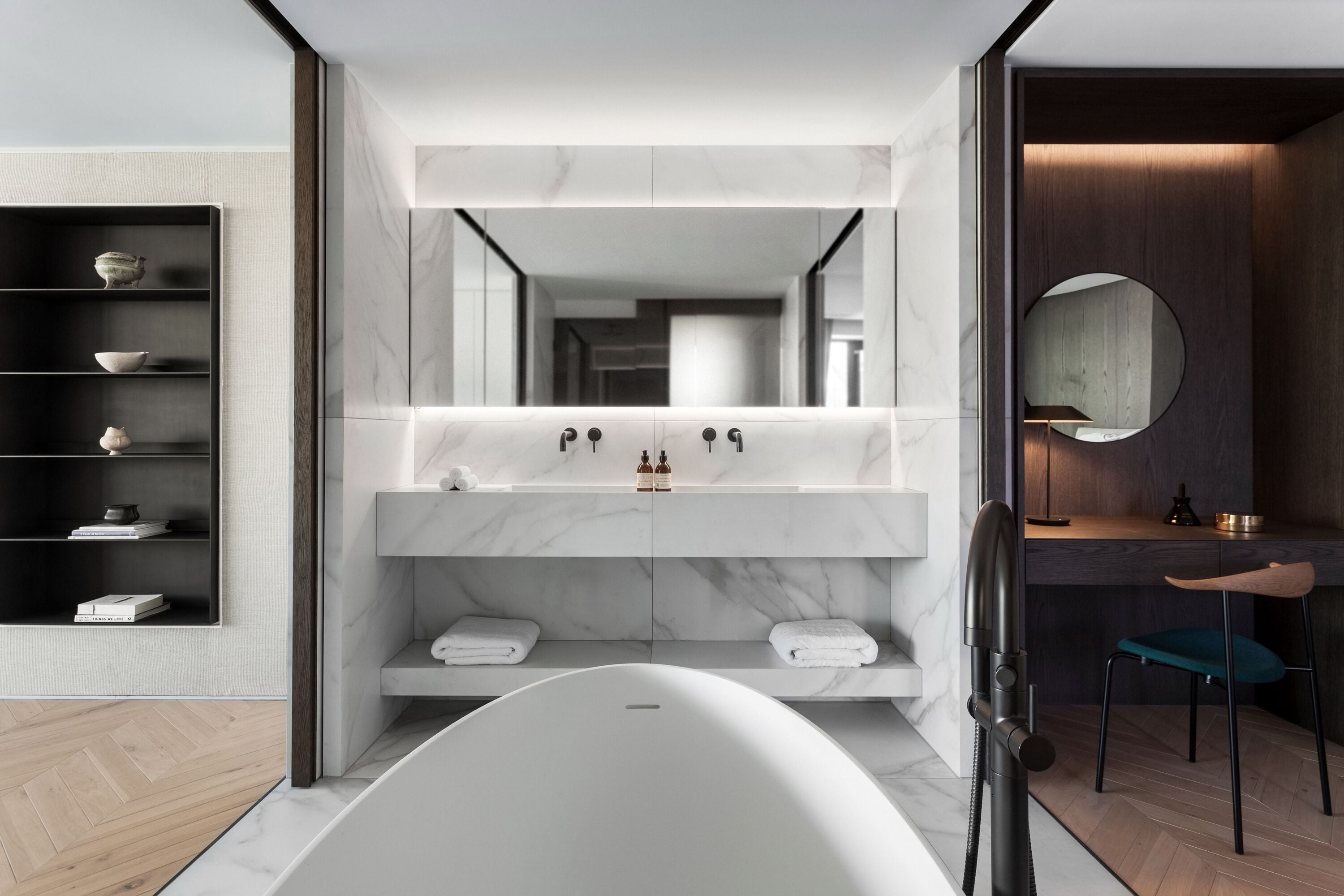 A modern bathroom with a freestanding bathtub, a large mirror, and a wooden vanity.