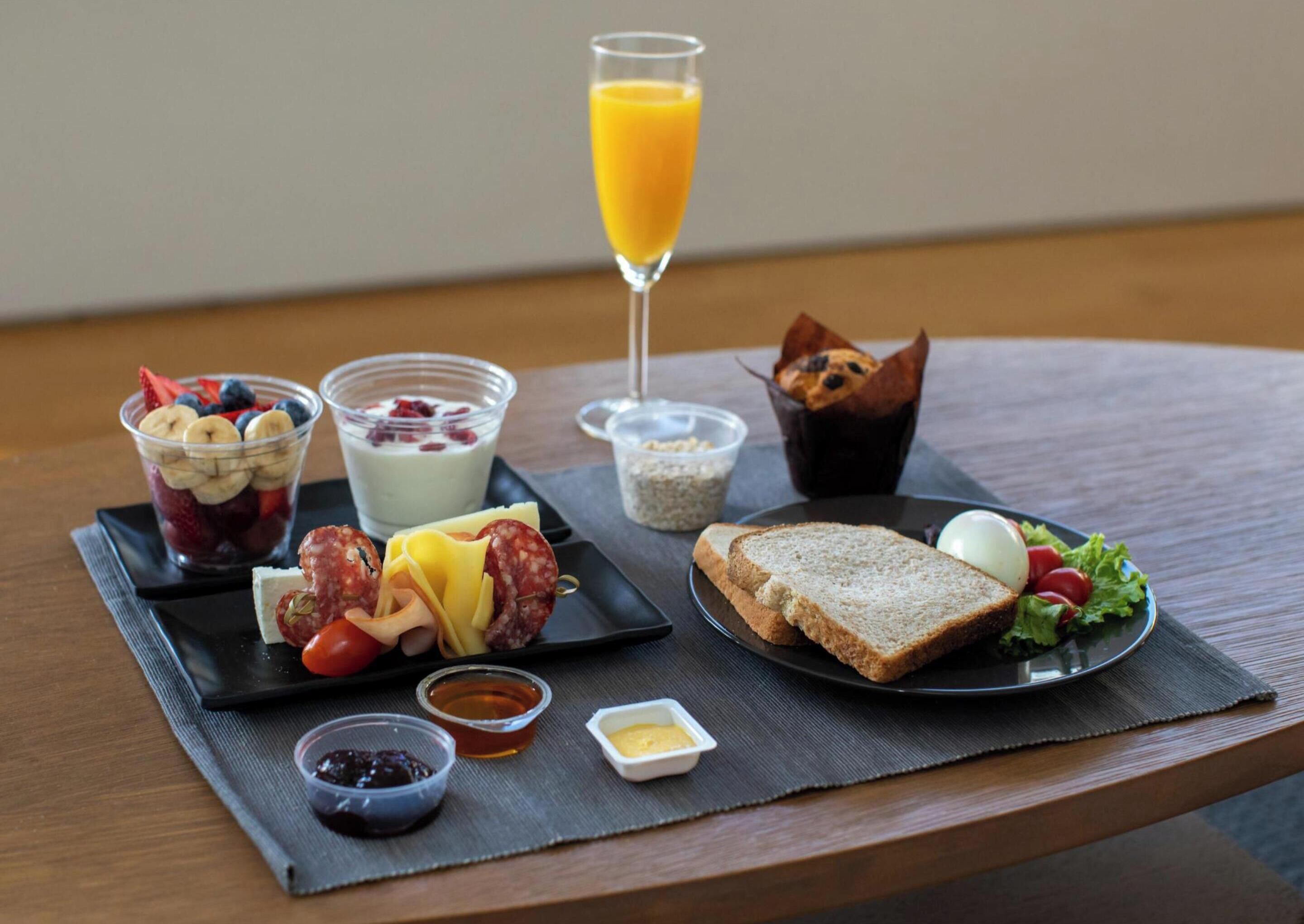 A breakfast setting with toast, eggs, and a glass of orange juice on a wooden table.