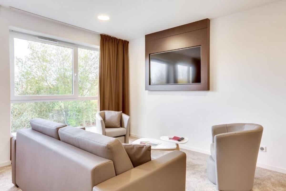 Un salon moderne avec un canapé, un fauteuil et une table basse.
