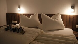 A hotel room with a bed, two wall-mounted lights, and a nightstand with a lamp. - Apart Felsenhof (Laengenfeld)