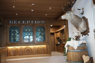 A reception area with wooden paneling, a mounted deer head, and a sign that reads "RECEPTION".