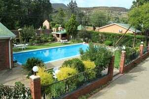 Un barrio residencial con piscina, casas de ladrillo y un patio cercado.