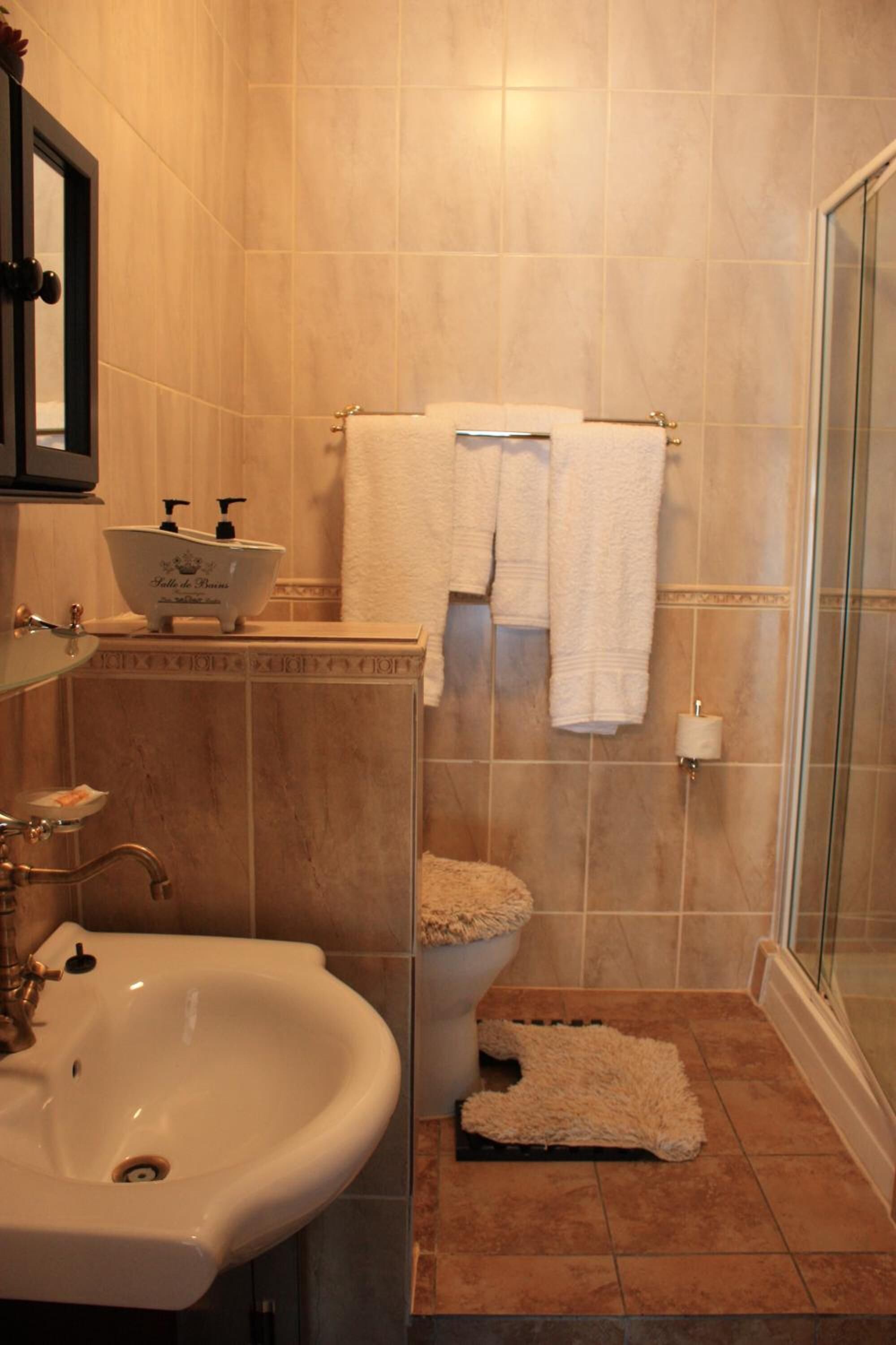 A bathroom with a sink, toilet, and shower area.
