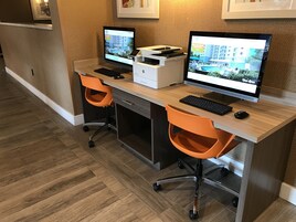 A modern office space with two desks, each equipped with a desktop computer, keyboard, and mouse.