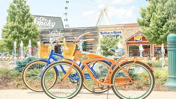 Una noria, una bicicleta azul y naranja, y un edificio con un letrero que dice 'Build a Bear'.