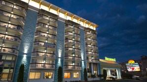 Un hôtel à plusieurs étages doté de balcons, d’une piscine et d’une enseigne indiquant le restaurant «The Island».