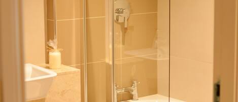 A modern bathroom with a glass-enclosed shower, a white bathtub, and a wooden vanity.