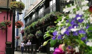 A building with multiple balconies adorned with hanging flower baskets.