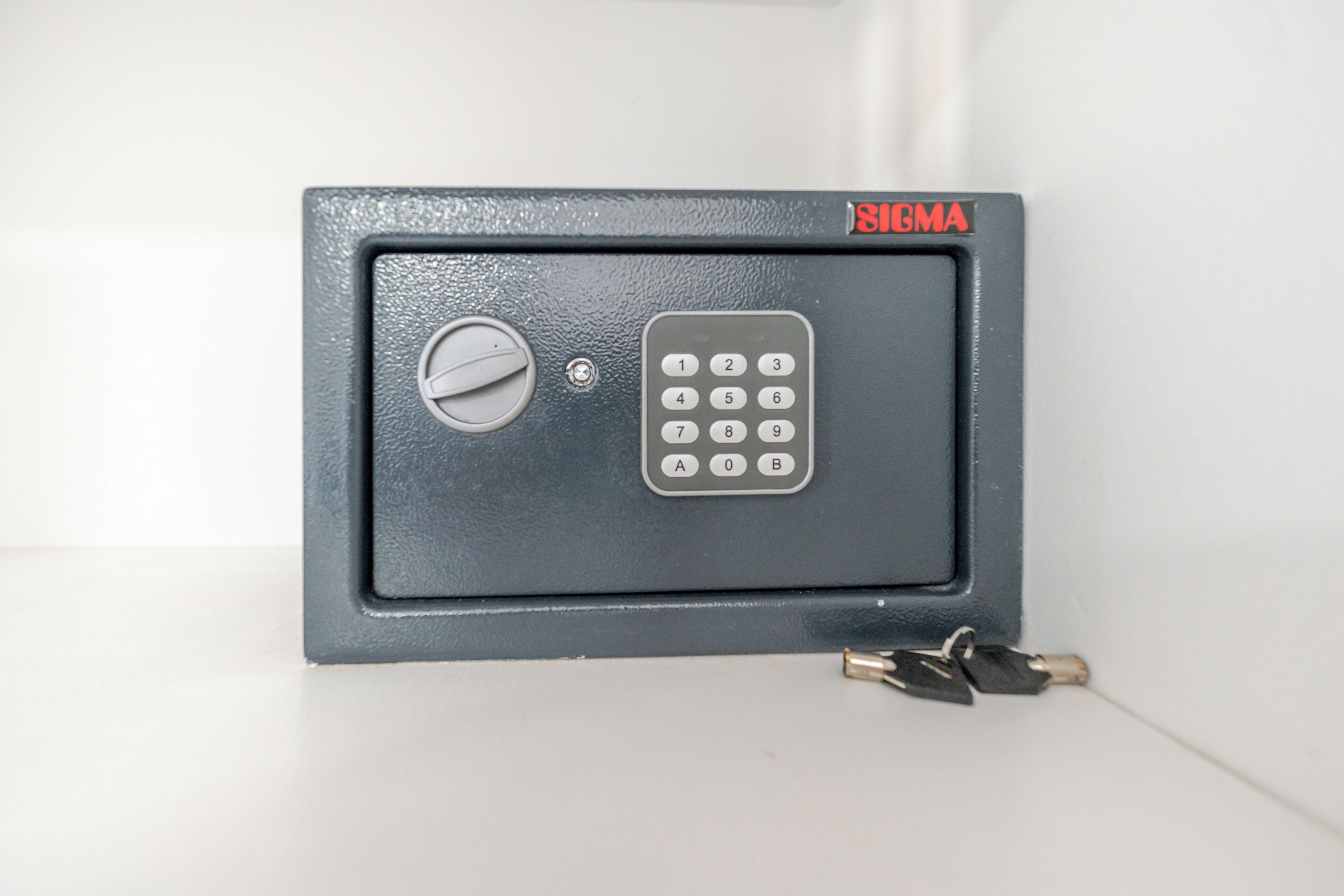 A black safe with a numeric keypad and a keyhole, labeled 'SIGMA.'