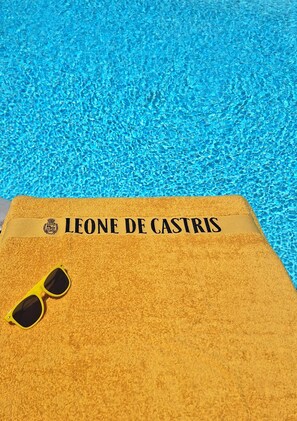 Ein Handtuch mit dem Aufdruck "LEONE DE CASTRIS", platziert am Pool.