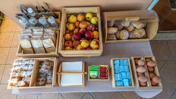 A table with various food items including bread, pastries, apples, and eggs.
