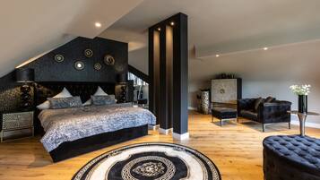 A modern bedroom with a large bed, a black headboard, and a decorative wall panel.