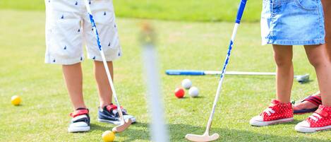 Un campo de golf con jugadores y un palo de golf.