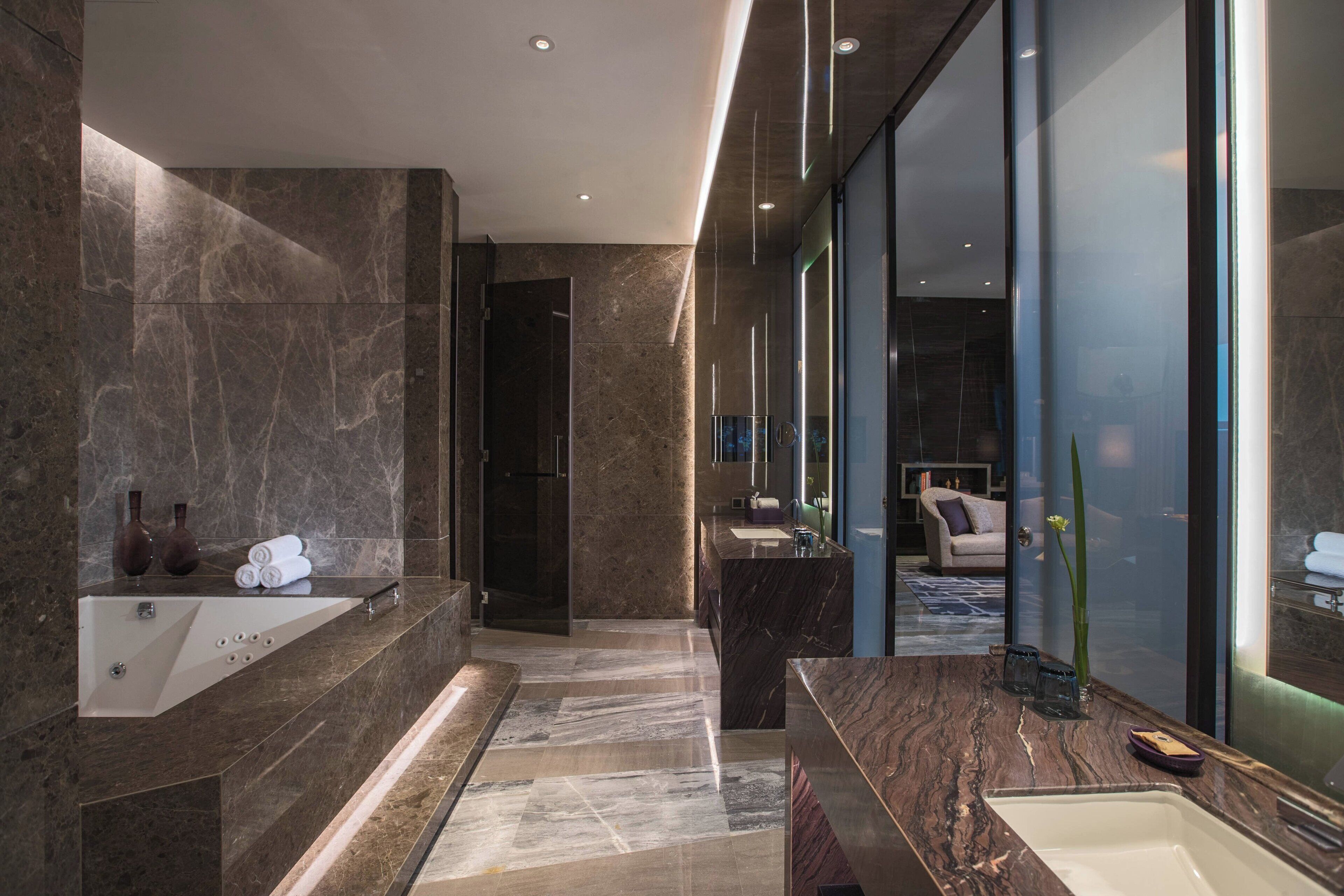 A modern bathroom with a large bathtub, a separate sink, and a glass-enclosed shower area.