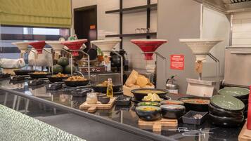 A buffet counter with various dishes and condiments.
