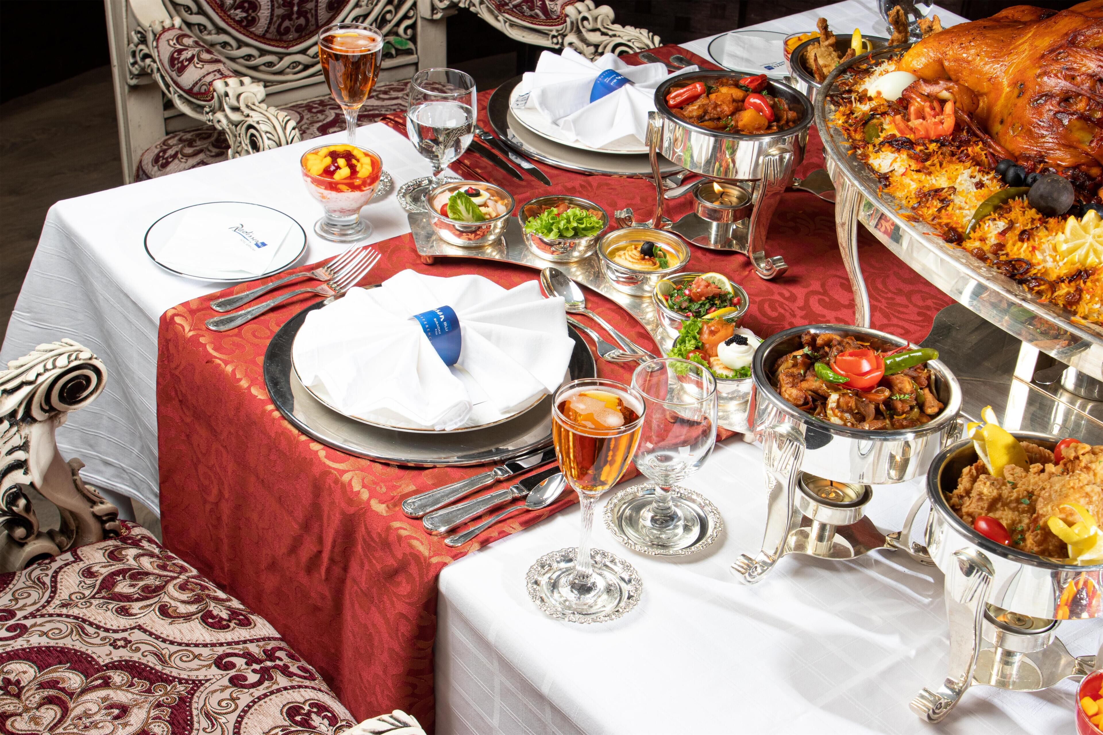 Una mesa puesta para una comida con varios platos, cubiertos y vasos.