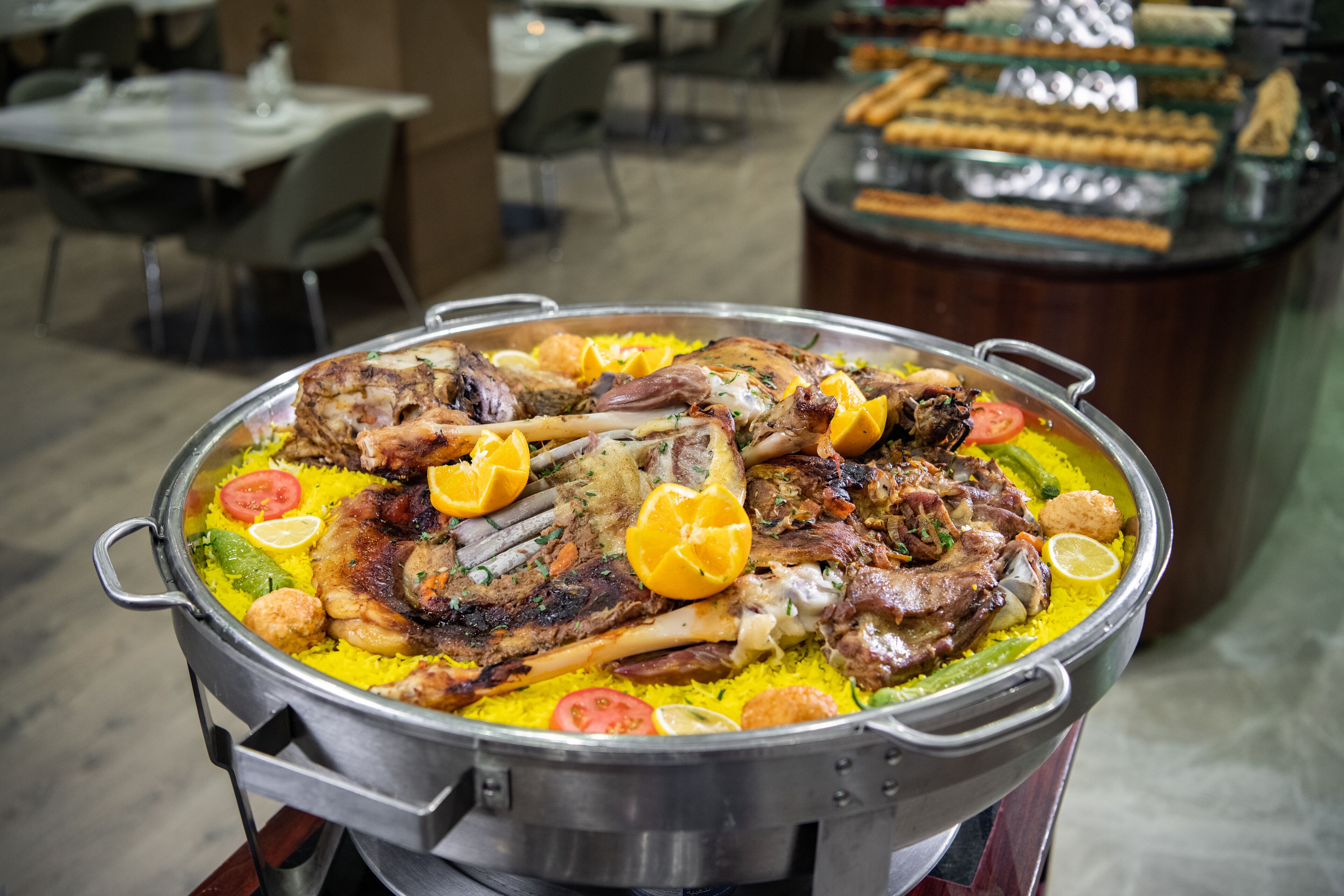A large pot of food with various meats and vegetables on a table in a dining area.
