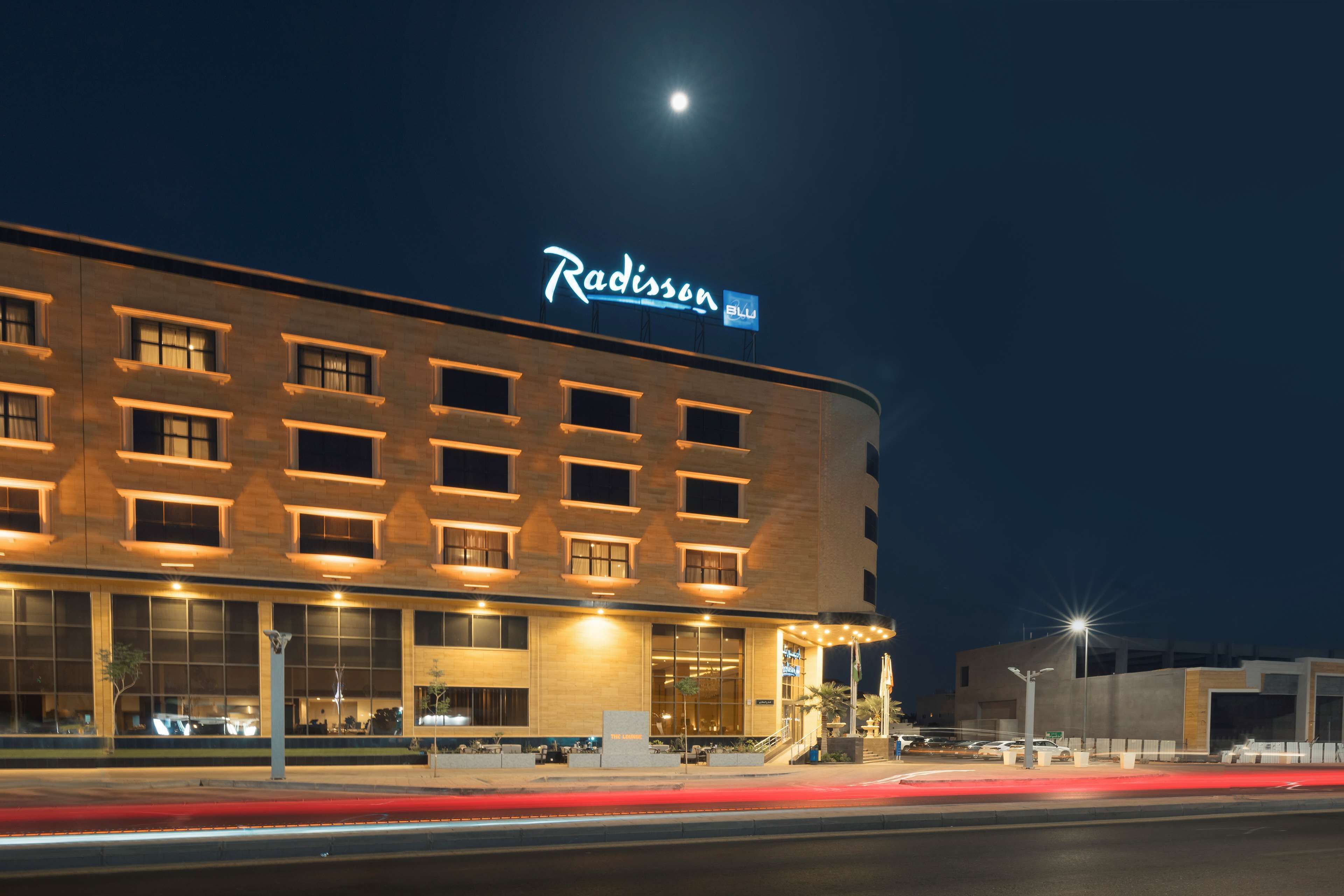 A Radisson hotel with a modern facade, large windows, and a prominent sign.