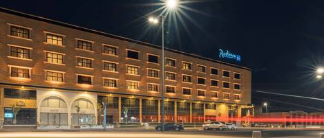 A hotel with a modern facade, multiple windows, and a prominent sign.