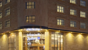 A hotel with a modern facade, large windows, and a prominent sign for 'Radisson Blu'. - Radisson Blu Hotel, Buraidah (Buraydah)