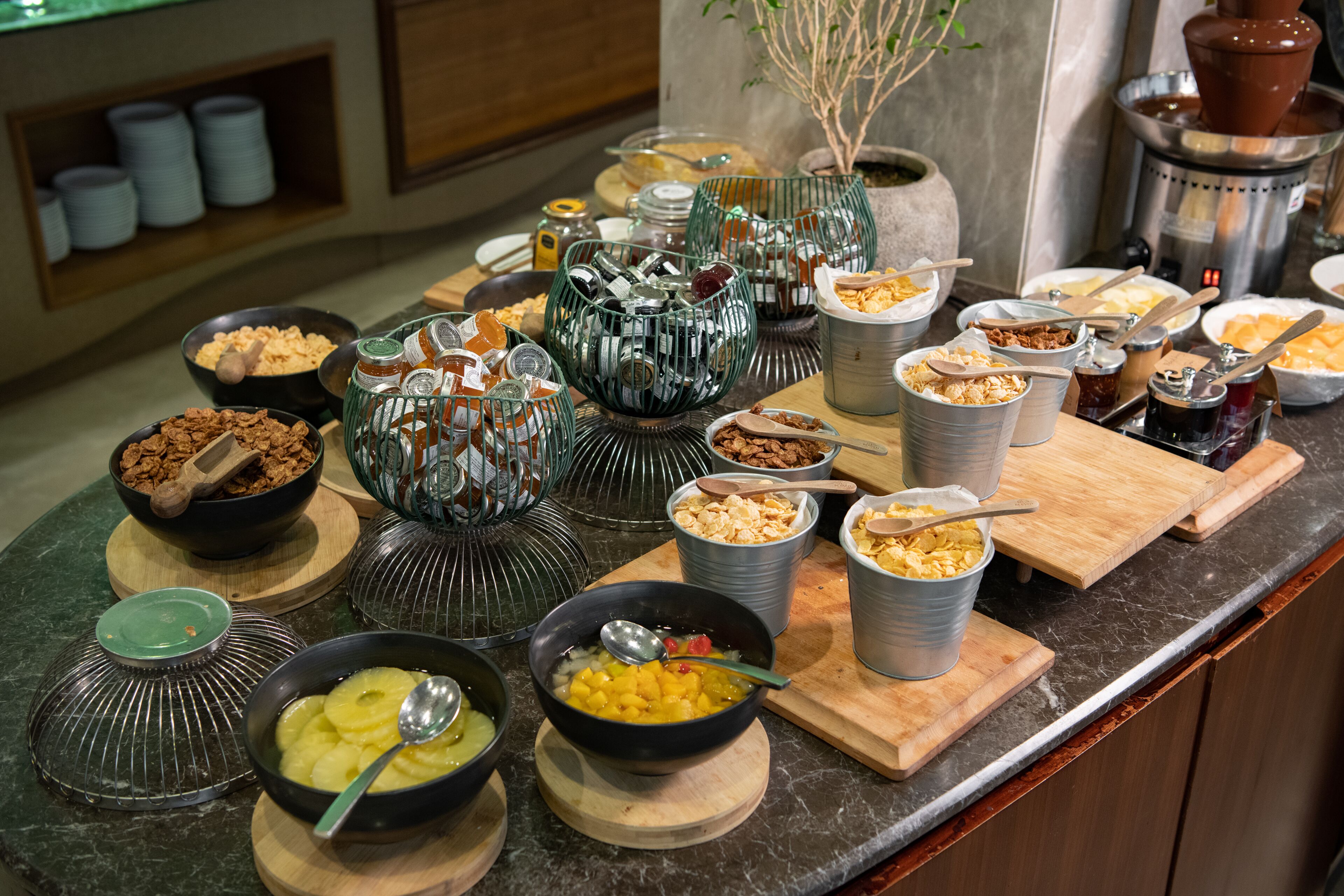 A buffet with various food items and utensils.