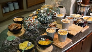 A buffet with various food items and utensils.