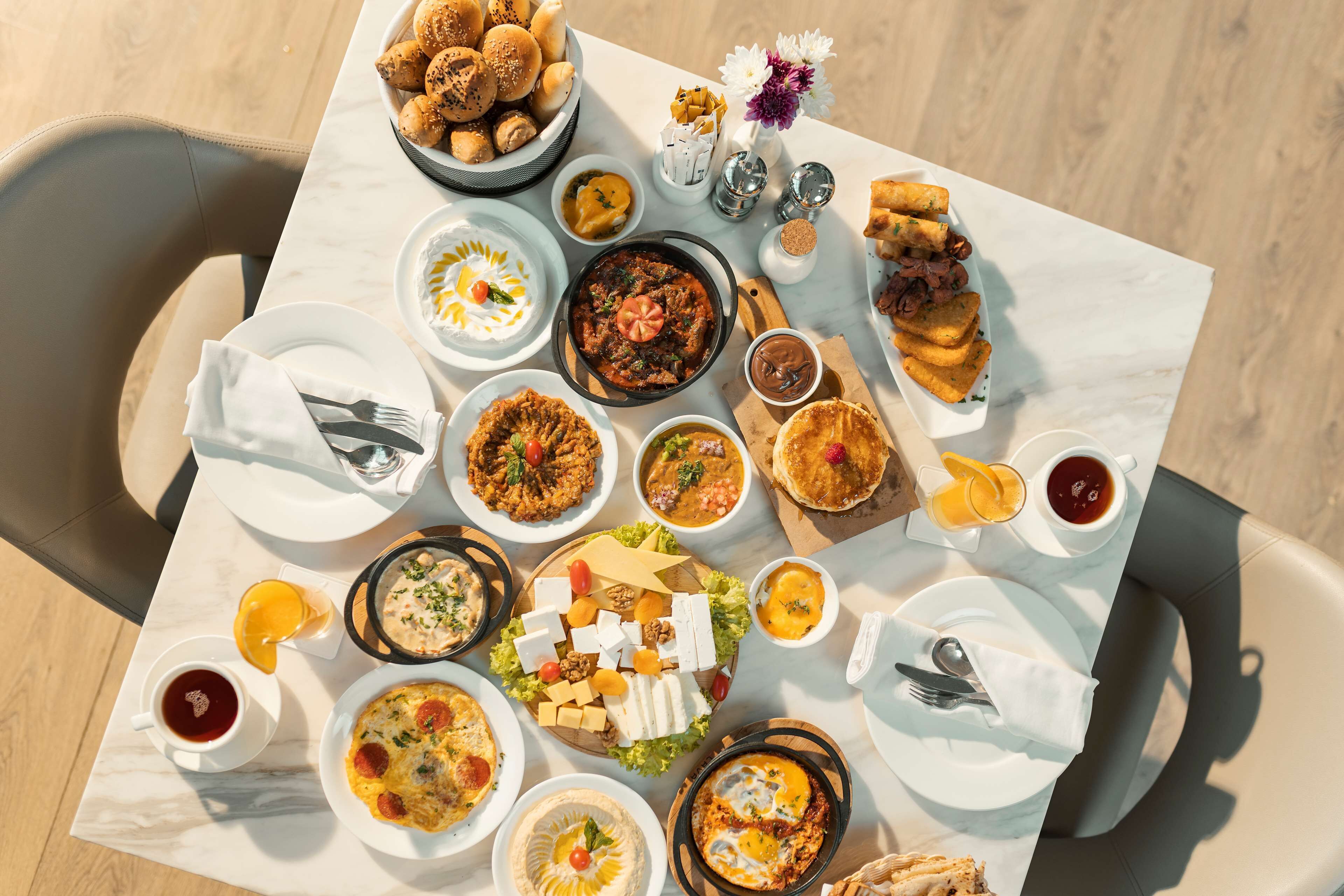 Une table dressée avec différents plats, notamment un bol de soupe, une assiette de pain et une tasse de café.