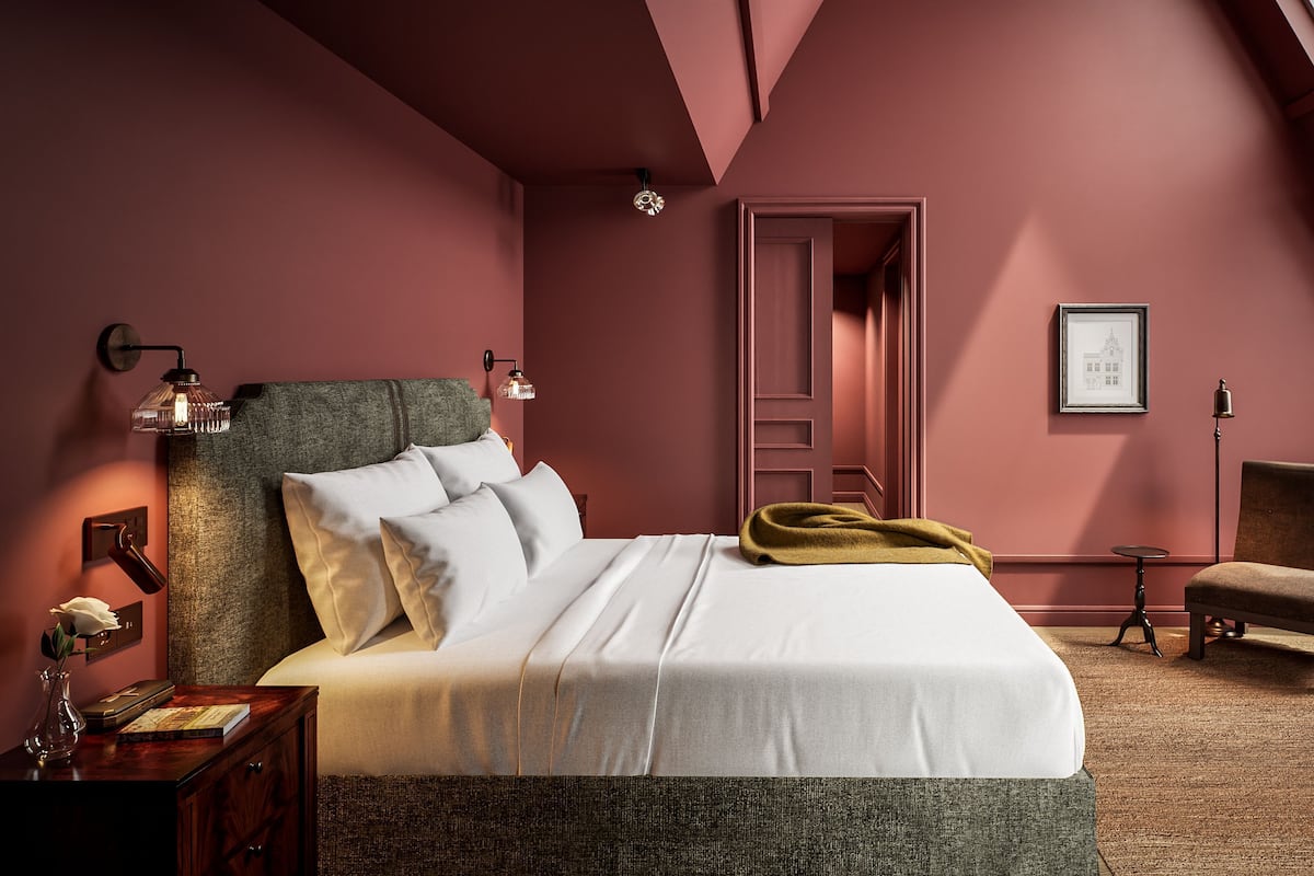 A bedroom with a bed, bedside tables, a chair, a small table, and a framed picture on the wall.