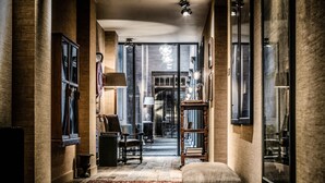 A hallway with a wooden floor, a bench, and a bookshelf. - 1898 The Post & Porter's house (Ghent)