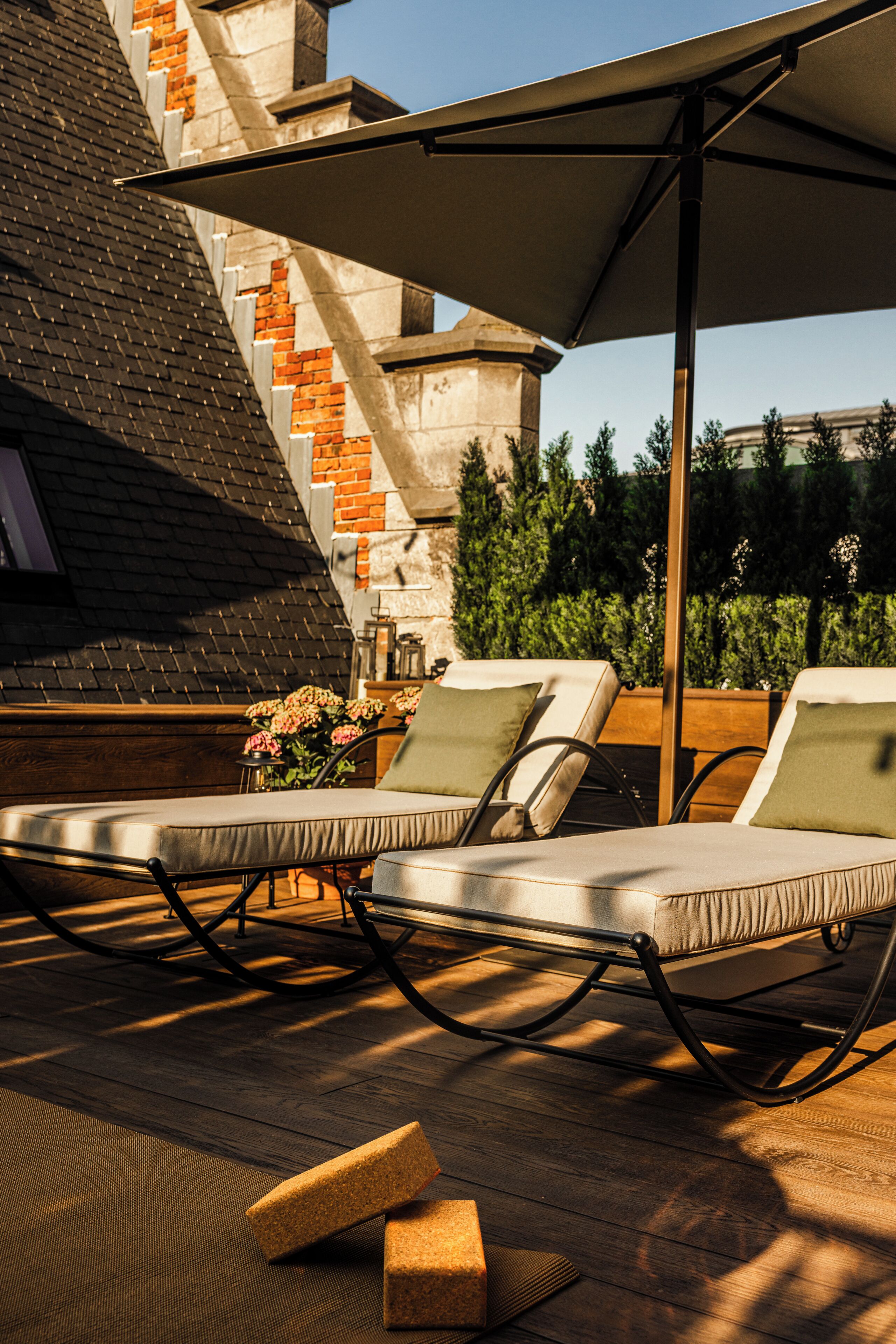 Un área de estar al aire libre con luz solar, sillones y una terraza de madera.